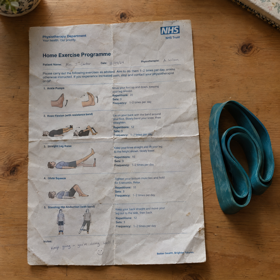 An NHS home exercise programme sheet beside a resistance band